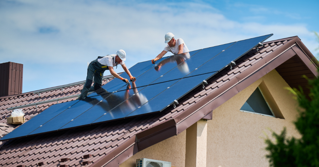 Como calcular o consumo de energia solar? Homens instalando painéis solares