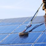 homem realizando limpeza de placa solar